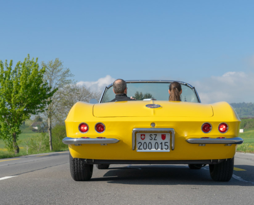 Corvette driving away Ansicht fahrende Corvette von hinten mit zwei Insassen