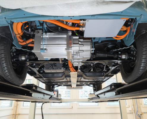 View from below showing the motor Blick auf den Unterboden eines Fahrzeugs. Man sieht Kabel, einen Elektromotor mit Getriebe/Differential.