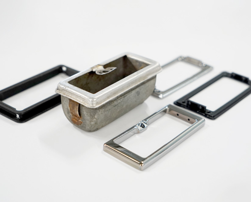 The ashtray is no longer needed. In its place, a display will be installed; the frame is a replica of the ashtray’s frame Ein Aschenbecher aus einem Fahrzeug, ausgebaut. Rund herum 3D-gedruckte Teile, die den Rahmen des Aschenbechers nachbilden. 2 der 4 Teile sind verchromt, die anderen roh, aus schwarzem Kunststoff.
